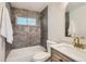 Modern bathroom boasts gray tile and a white vanity with marble countertop at 130 S Eaton St, Lakewood, CO 80226