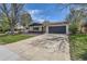 Charming ranch home featuring a two-car garage and a well-maintained front yard with mature trees and a long driveway at 130 S Eaton St, Lakewood, CO 80226