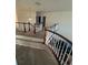 Bright hallway with carpeted floors and wood railing at 14241 Ivanhoe St, Thornton, CO 80602