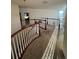 Bright hallway with carpeted floors and wood railing at 14241 Ivanhoe St, Thornton, CO 80602