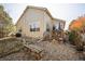 Backyard with rock bed, wood bench and stairs up to back deck and grill at 1563 Bellflower Dr, Brighton, CO 80601