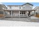 Home's backyard features a covered patio, rock landscaping, and views of the neighborhood at 2598 Knobbie Cir, Castle Rock, CO 80109