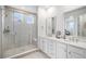 Bright bathroom with glass shower, double vanity, and sleek tile flooring at 2598 Knobbie Cir, Castle Rock, CO 80109