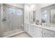 Bright bathroom features a glass enclosed shower, and a dual sink vanity with modern finishes at 2598 Knobbie Cir, Castle Rock, CO 80109