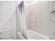 Bathroom with a white bathtub and shower featuring light-colored vertical tiles at 2598 Knobbie Cir, Castle Rock, CO 80109