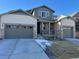 Inviting home featuring a three car garage, covered porch and stone accents at 2598 Knobbie Cir, Castle Rock, CO 80109