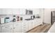 Modern kitchen features white cabinets, stainless steel microwave, gas cooktop, and light wood flooring at 2598 Knobbie Cir, Castle Rock, CO 80109