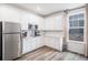 Kitchen featuring stainless steel refrigerator, white cabinets, and a corner window at 2598 Knobbie Cir, Castle Rock, CO 80109