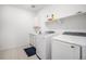 Neat laundry room with modern washer and dryer, cabinetry, storage shelves, a sink, and tile floor at 2598 Knobbie Cir, Castle Rock, CO 80109