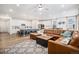 Bright open concept living room and kitchen with a large leather sofa at 2598 Knobbie Cir, Castle Rock, CO 80109
