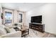 Bright living room showcases an electric fireplace, plush sofa, and large windows for ample light at 2598 Knobbie Cir, Castle Rock, CO 80109