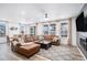 Open-concept living room featuring a brown leather sectional, modern lighting, and large windows at 2598 Knobbie Cir, Castle Rock, CO 80109