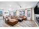 Bright living room area featuring lots of windows, a leather sectional, and adjacent dining room at 2598 Knobbie Cir, Castle Rock, CO 80109