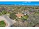 Aerial shot of a home with a fenced yard, mature trees, and a mountain range in the background at 3906 Hoyt Ct, Wheat Ridge, CO 80033
