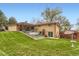 Expansive backyard featuring patio, lush lawn, mature trees, and privacy fencing at 3906 Hoyt Ct, Wheat Ridge, CO 80033