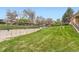 Backyard featuring a large lawn area with iron fence and retaining wall at 3906 Hoyt Ct, Wheat Ridge, CO 80033