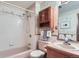 Classic bathroom featuring tiled walls, a tub with shower, and vintage wood cabinet at 3906 Hoyt Ct, Wheat Ridge, CO 80033