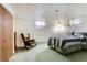 Basement bedroom offers a quiet retreat, furnished with a cozy rocking chair and comfortable bed at 3906 Hoyt Ct, Wheat Ridge, CO 80033