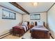 Quaint bedroom featuring two beds, natural light, and charming decor at 3906 Hoyt Ct, Wheat Ridge, CO 80033