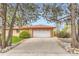Exterior shot showcasing the home's garage, long driveway, and brick accents at 3906 Hoyt Ct, Wheat Ridge, CO 80033