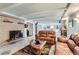 Spacious living room featuring a brick fireplace, beamed ceiling, and comfortable leather seating at 3906 Hoyt Ct, Wheat Ridge, CO 80033
