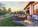 Charming outdoor space with a stone fire pit, comfortable seating, and lush landscaping at 10660 Winding Pine Pt, Highlands Ranch, CO 80126