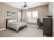 Bedroom with large window, black furnishings and neutral color palette at 10660 Winding Pine Pt, Highlands Ranch, CO 80126