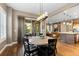 Elegant dining area with a round wooden table and chairs, adjacent to a cozy living area with a fireplace at 10660 Winding Pine Pt, Highlands Ranch, CO 80126