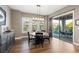 Charming dining room with a round wooden table, black chairs, and a sliding door leading to an outdoor patio at 10660 Winding Pine Pt, Highlands Ranch, CO 80126