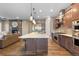 Bright kitchen with stainless steel appliances, a large island, and a cozy fireplace in the adjacent living area at 10660 Winding Pine Pt, Highlands Ranch, CO 80126
