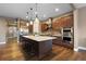 Well-equipped kitchen with stainless steel appliances, a large island with stools, and wooden cabinets at 10660 Winding Pine Pt, Highlands Ranch, CO 80126