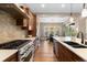 Modern kitchen with stainless steel appliances, wooden cabinets, and a view of the dining room at 10660 Winding Pine Pt, Highlands Ranch, CO 80126