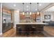 Gorgeous kitchen with stainless steel fridge, kitchen island with stools, wooden cabinets and stainless steel appliances at 10660 Winding Pine Pt, Highlands Ranch, CO 80126