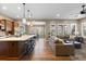 Bright, open-concept living room features hardwood floors, natural light, and modern pendant lighting at 10660 Winding Pine Pt, Highlands Ranch, CO 80126