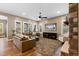 Spacious living room featuring hardwood floors, large windows, and a stone fireplace at 10660 Winding Pine Pt, Highlands Ranch, CO 80126