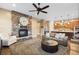 Cozy living room with a stone fireplace, hardwood floors, and open access to the kitchen at 10660 Winding Pine Pt, Highlands Ranch, CO 80126