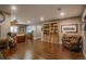 Spacious living room with hardwood floors, a built-in bookcase, and a leather chair at 10660 Winding Pine Pt, Highlands Ranch, CO 80126