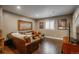 Relaxing living room with a comfortable leather couch, media center, and window shutters at 10660 Winding Pine Pt, Highlands Ranch, CO 80126
