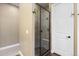 Tiled shower with a glass door, built-in seat and decorative stone floor at 10660 Winding Pine Pt, Highlands Ranch, CO 80126