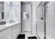 Bright bathroom features a double vanity, framed mirrors, and glass-enclosed shower with tile surround at 802 Eva Peak Dr, Erie, CO 80516