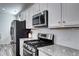 Well-equipped kitchen featuring modern stainless-steel appliances, sleek white cabinets and ample countertop space at 802 Eva Peak Dr, Erie, CO 80516