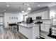 Open kitchen with white cabinets, modern stainless-steel appliances, granite countertops, and an island at 802 Eva Peak Dr, Erie, CO 80516