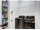 Laundry room with dark washer and dryer, storage shelves, and a convenient layout at 802 Eva Peak Dr, Erie, CO 80516