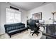 Home office with sofa, desk, and monitors, illuminated by natural light from a window at 802 Eva Peak Dr, Erie, CO 80516