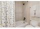 Bright bathroom showcasing a tub/shower combo with a geometric curtain and white tile surround at 1385 Birch St, Denver, CO 80220