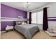 Bedroom with purple accent wall, plush accents, carpet and unique lighting fixture at 1385 Birch St, Denver, CO 80220