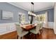 Elegant dining room with modern lighting fixture, hardwood floors, and picture-frame molding at 1385 Birch St, Denver, CO 80220