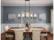 Elegant dining room with modern lighting fixture, hardwood floors, and picture-frame molding at 1385 Birch St, Denver, CO 80220