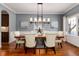 Elegant dining room with modern lighting fixture, hardwood floors, and picture-frame molding at 1385 Birch St, Denver, CO 80220