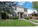 Well-maintained two-story home featuring a manicured lawn, mature trees, and brick accents at 1385 Birch St, Denver, CO 80220